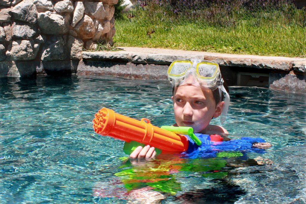 Kid in the pool with super soakers